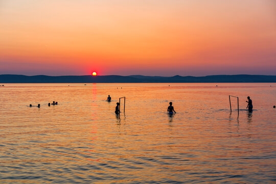 People playing water polo at sunset in Lake Balaton in Hungary