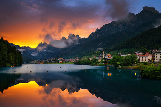 Auronzo lake reflecting Dolomites mountains sunset light in Italy