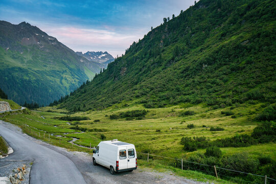 Camper van with solar panels traveling in the Austrian alps