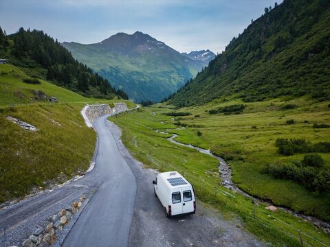 Camper van with solar panels traveling in the Austrian alps