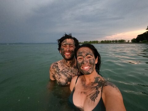 Smiling couple enjoying mud bath in Lake Balaton, Hungary