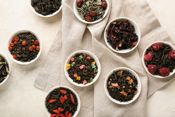 Bowls with different fruit tea on light grunge background
