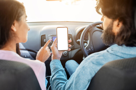 Indian couple using smartphone with blank white screen in car, pointing and discussing. Ideal for mockups, UI UX design and digital content concepts, mockup - Powered by Adobe