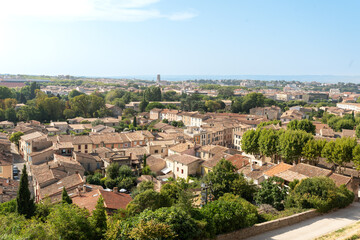 Obraz premium Aerial view of the modern part of Carcassonne with tiled rooftops and trees in summer light.