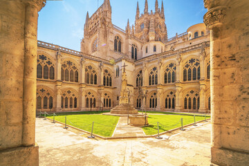 Historic courtyard with stone arches and Gothic windows in Burgos Cathedral.