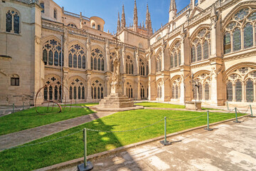 Historic courtyard with stone arches and Gothic windows in Burgos Cathedral.