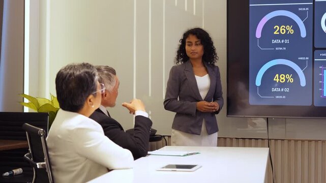 Female presenter shares sales statistics and strategy report on large screen in corporate seminar. Diverse team engages in planning, collaboration, leadership, and partnership during employer meeting.