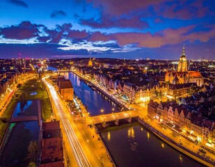Fototapeta premium Aerial Night View of a European City with Bridges over a River and City Lights