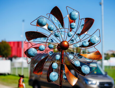 Copper wind spinner with blue accents on clear day outdoors