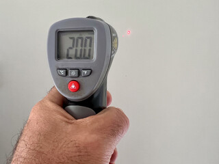 Hand of a person using Infrared thermometer
