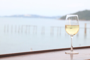 glass of cold white wine on the summer seashore by the water, relaxing by the water, a gentle background of soft color