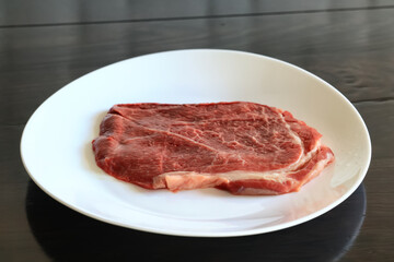 a piece of raw meat, steak on a plate, beef