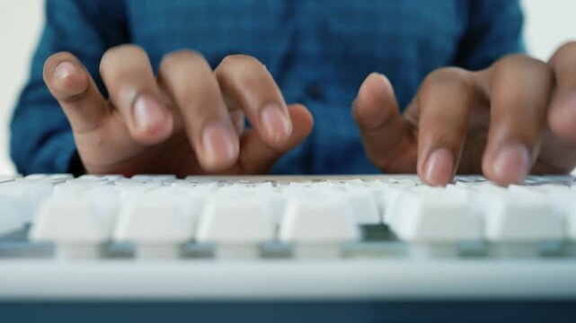 Hands Typing on White Keyboard, Close-up of hands typing on a white keyboard, wearing a blue plaid shirt
