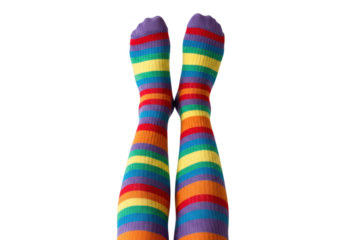 Vibrant rainbow striped socks covering legs against black studio background isolated on transparent background