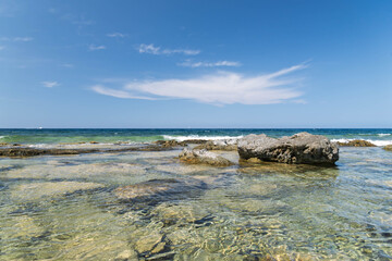 Tranquil Mediterranean seaside with clear waves and natural rocks, great for wellness projects, travel posters, or marine conservation materials.