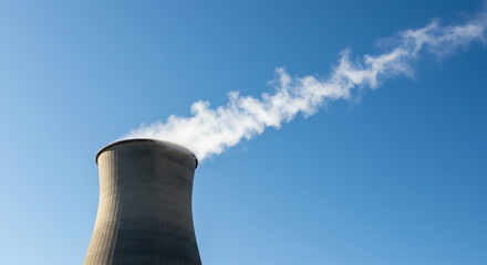 Cooling Tower with Vapor Trail Against Clear Blue Sky, Energy Production and Environmental Impact