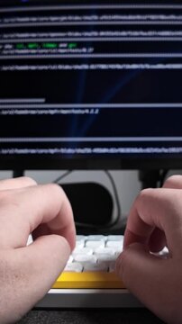 Hands typing on a white keyboard with yellow spacebar, engaging with programming code on blurred computer screen, representing modern software development. Zoom. Vertical