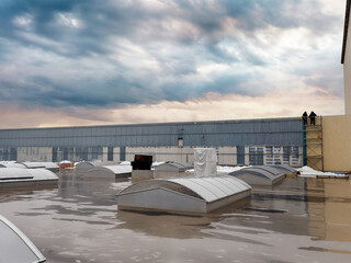 Industrial rooftop scene with workers and dramatic sky