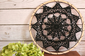 Autumn still life with crochet doily, pumpkin, dried hydrangea flowers, yarn, and pumpkin-shaped mug on rustic wooden surface. Warm cozy composition for handmade, home, or seasonal design.