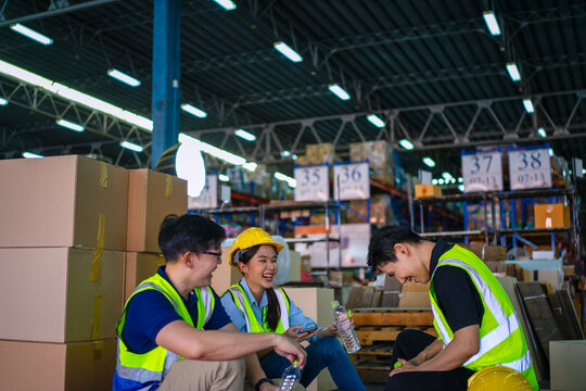 Blue collar workers are working at warehouse.