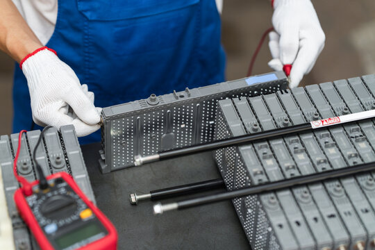Serviceman testing electric car battery pack during diagnostics
