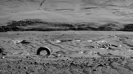 Tyre in muddy river bank