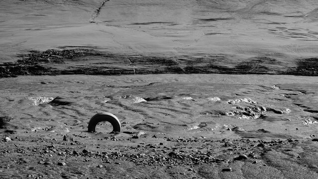 Tyre in muddy river bank