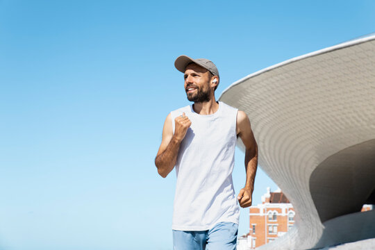 Runner smiling during a morning run near MAAT in Lisbon