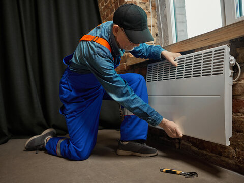 Repairman checking electric radiator installation for home heating system. Concept of household safety, energy maintenance, and sustainable utilities for editorial and e-commerce illustration.