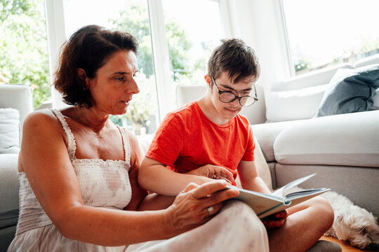 Mother and son with trisomy 21 bonding over a photobook at home