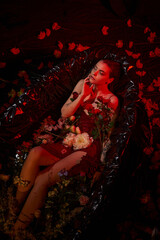 Naklejka premium Seductive young woman in water surrounded by flowers in a creative fashion shoot