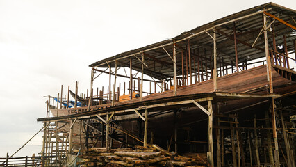 A traditional wooden phinisi ship, which is the pride of the Bugis Makassar community, is being built at a shipyard on the coast.