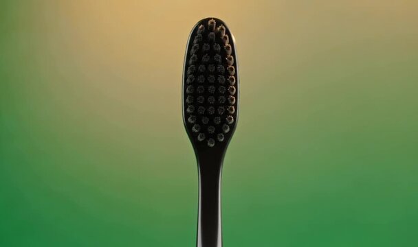 Close-up of a black toothbrush head against a vibrant green background, highlighting dental hygiene.