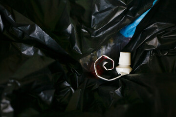 empty toothpaste tube on plastic trash bag