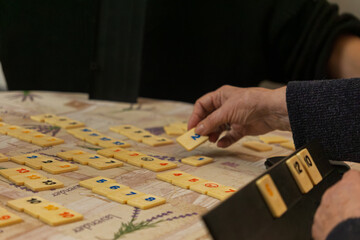 Elderly Hand Holding Game Piece.