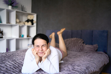 Obraz premium a senior woman in underwear stretching, resting, enjoying life on bed at home