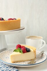 Delicious cheesecake with fresh berries and mint served on white table
