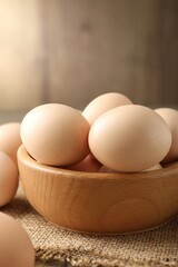 Raw chicken eggs in bowl on table, closeup
