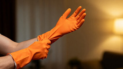 Person wearing orange cleaning gloves