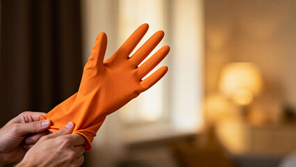 Person holding orange cleaning glove