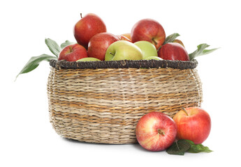 Fresh apples in wicker basket and green leaves isolated on white