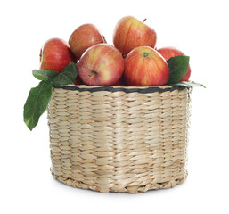 Fresh apples in wicker basket and green leaves isolated on white