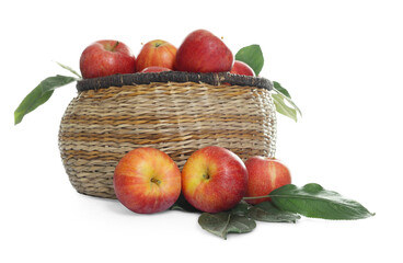 Fresh apples in wicker basket and green leaves isolated on white