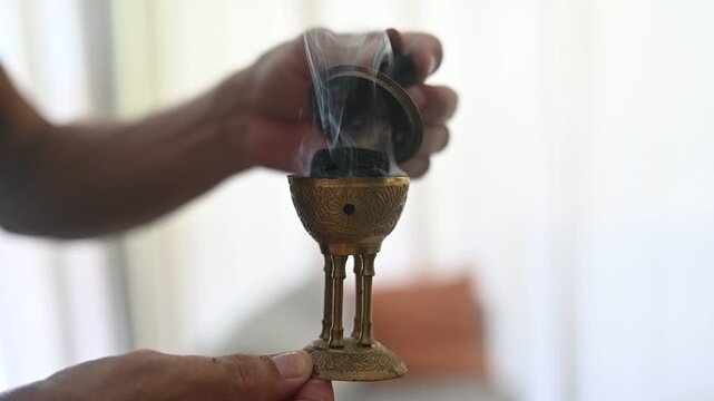 Person preparing traditional arabic bakhoor incense burner