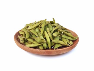Fresh green soybeans on wooden plate isolated on white background. High angle view 