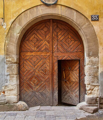 Massive ancient arched wooden gate with a geometric pattern.