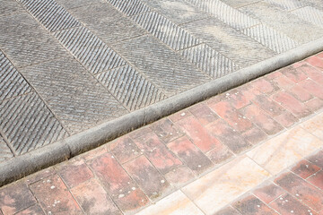 
New carved paving made with chiseled grey sandstone blocks in a italian pedestrian zone -...