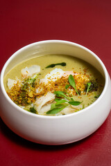 Traditional Portuguese codfish soup 'Açorda de Bacalhau', crafted by a chef, featuring bread, boiled egg, garlic, olive oil, and herbs in a gourmet presentation.