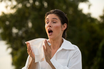 Outdoor shot of displeased Caucasian woman feels allergy