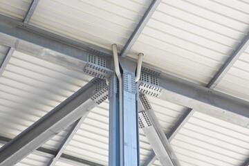 Modern metal roofing system featuring a prefabricated steel framework with columns, steel beams, and galvanized steel bolts.